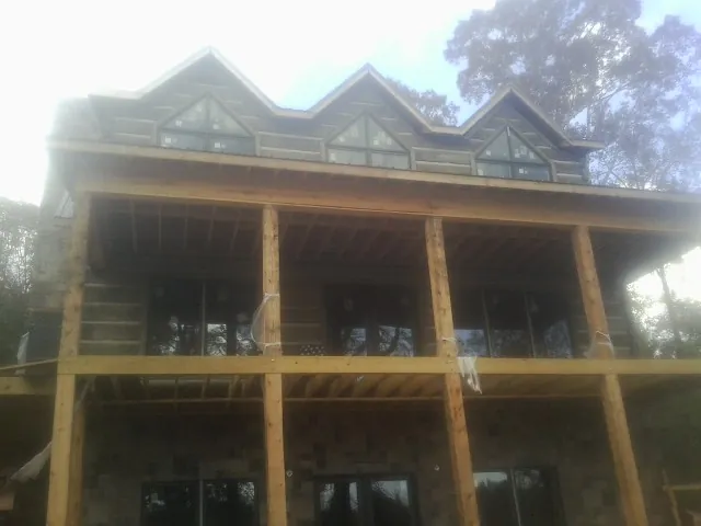 Dormers and porch framing on a large log home under construction — Roof Coating work by our crew in Cave City