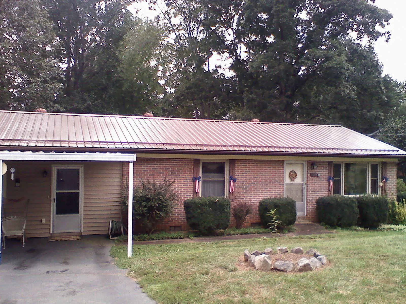 Bronze metal roof and carport on a brick ranch home — Roof Repair work by our crew in Cave City